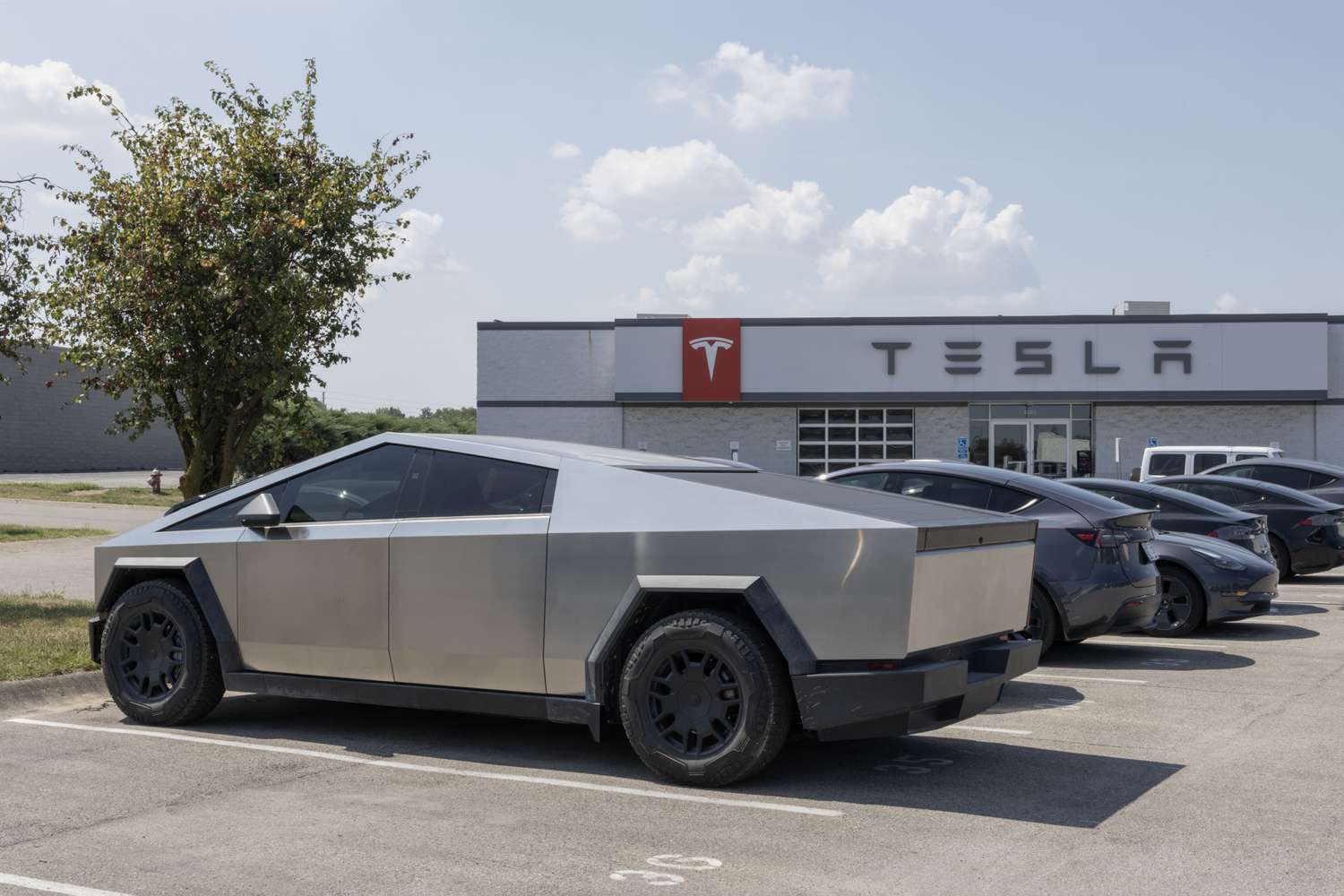 Analysts Reduce Target Prices for Tesla Stock Citing Tariffs in the Auto Industry 3 June 16, 2025 4:29 pm Analysts Reduce Target Prices for Tesla Stock Citing Tariffs in the Auto Industry Cars parked at a Tesla lot