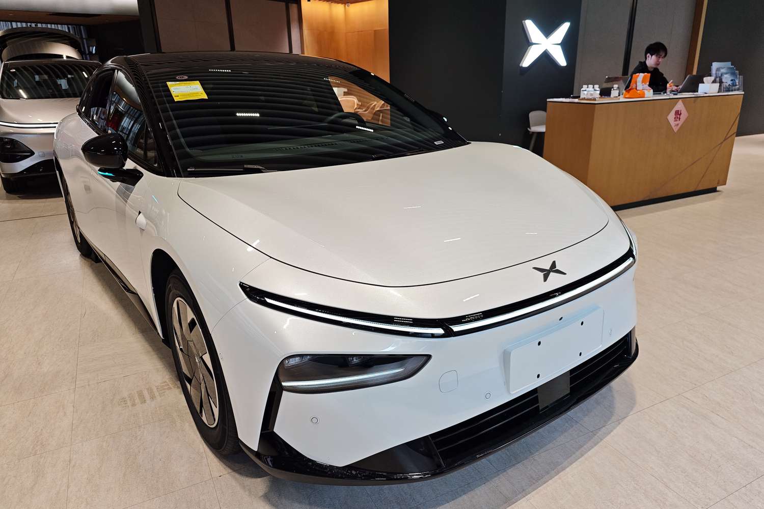 XPeng Inventory Slumps as EV Maker's Loss Narrows Much less Than Anticipated 3 April 20, 2025 12:29 am XPeng Inventory Slumps as EV Maker's Loss Narrows Much less Than Anticipated A white XPeng G6 car in a showroom, with a person sitting behind a desk to the right of the car