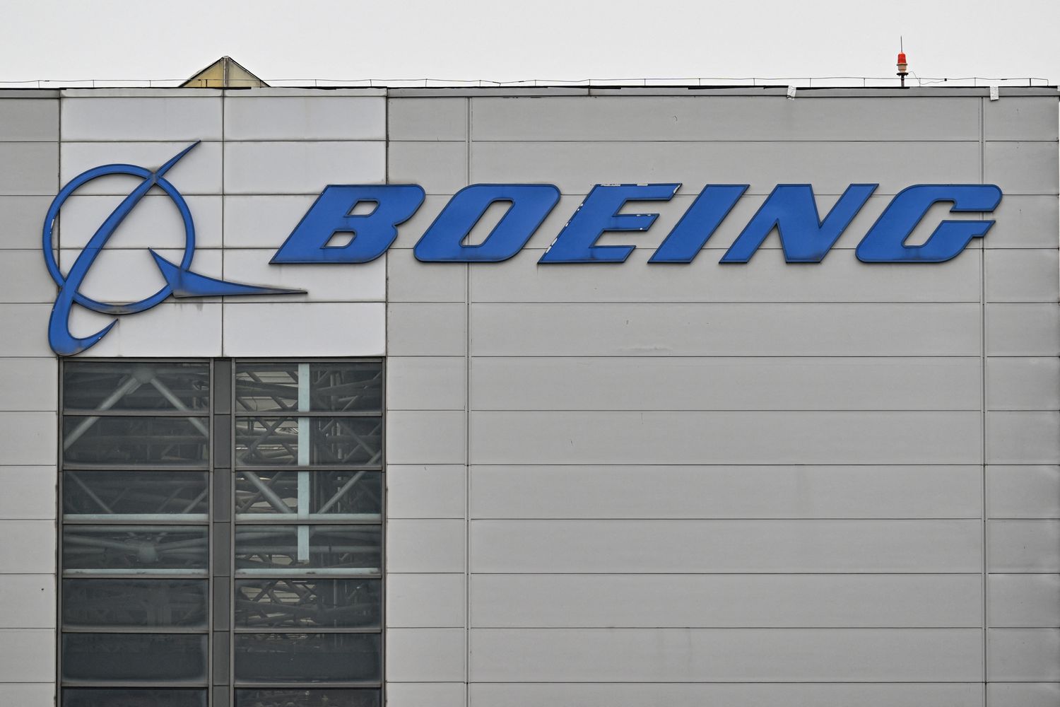 Boeing Stock Surges on Narrower-Than-Expected Loss 3 July 7, 2025 7:19 am Boeing Stock Surges on Narrower-Than-Expected Loss The blue Boeing logo is seen on the side of a gray building.