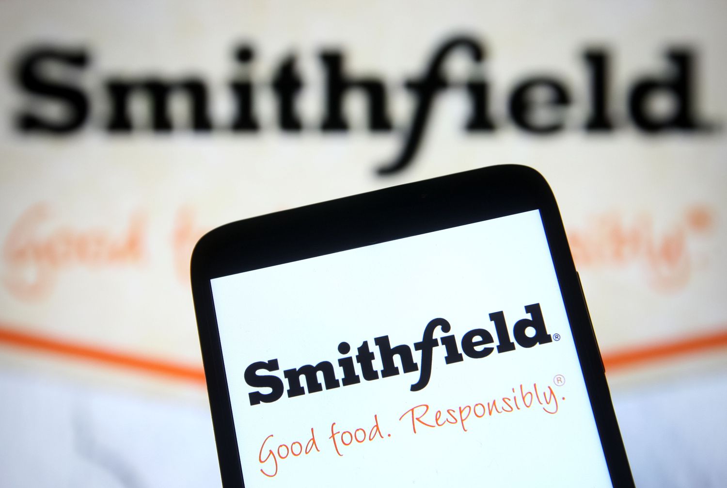 Smithfield Foods Stock Rises with the addition of Russell 1000 Index 3 June 13, 2025 6:05 pm Smithfield Foods Stock Rises with the addition of Russell 1000 Index The black and orange Smithfield logo is seen on a phone screen, with a larger version of the logo in the background.