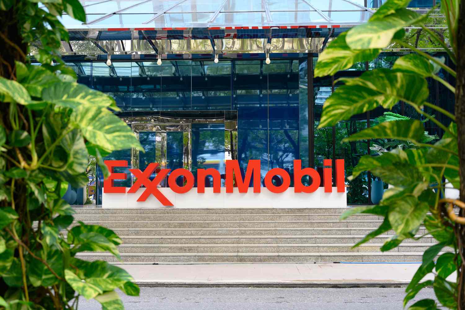 ExxonMobil, Chevron Prime Revenue Estimates 3 June 11, 2025 2:45 am ExxonMobil, Chevron Prime Revenue Estimates The red ExxonMobil logo is seen on a sign outside an office building, with green plants on both sides.